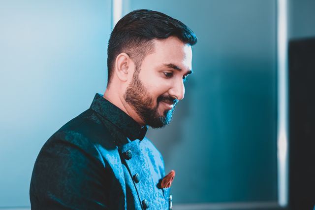 pexels-photo-6498090-6498090 Elegant portrait of a bearded man smiling in formal attire, highlighting details and mood.